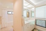 The master bathroom features two vanities with sinks, oversized soaking tub with shower, toilet, washer/dryer and closet